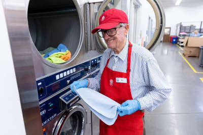 Worker puts laundry in washer